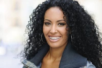 woman wearing traditional braces and smiling