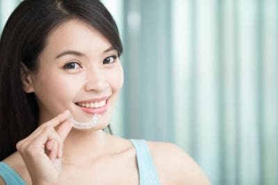 woman wearing clear aligners and smiling